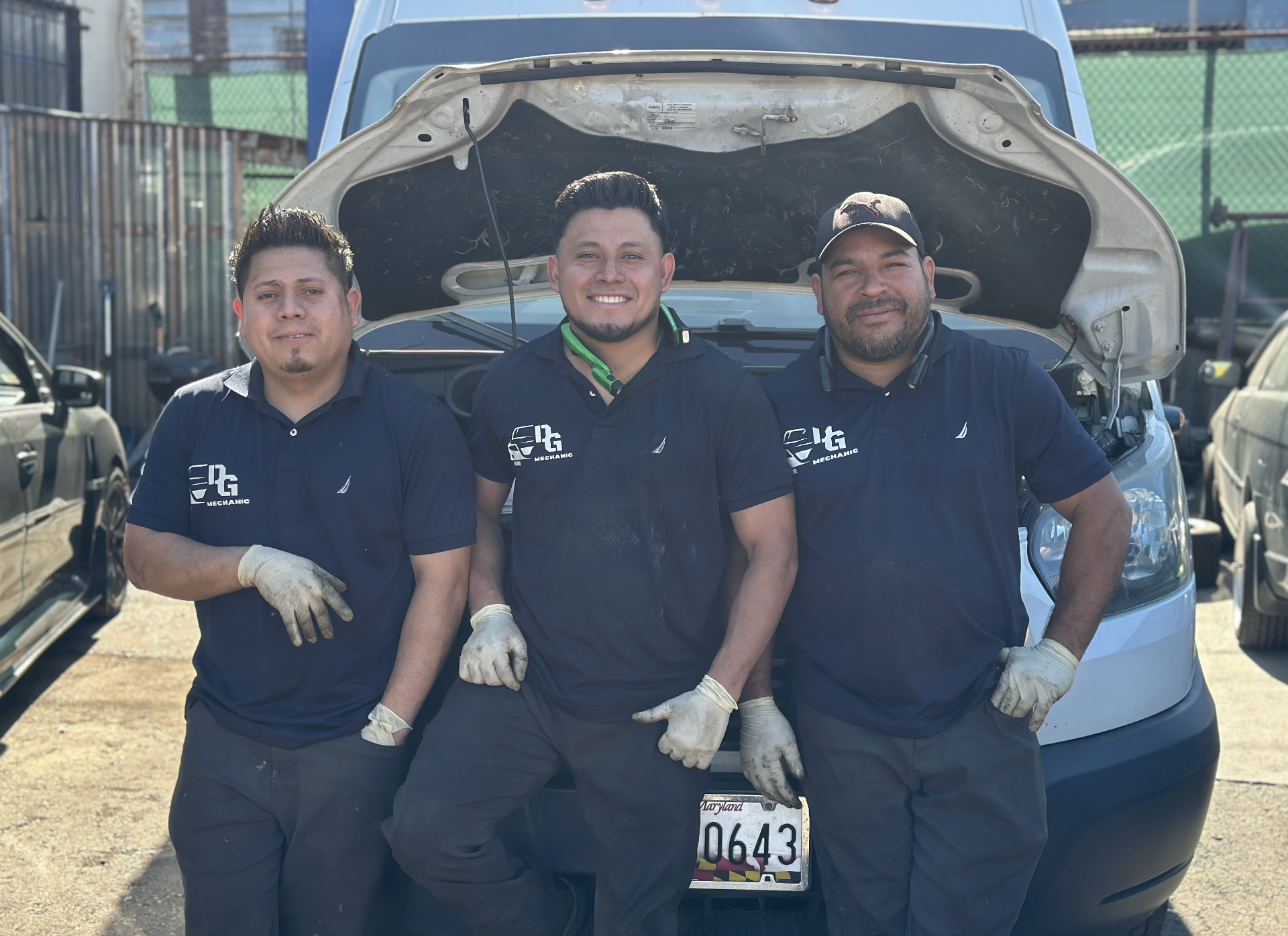 Three team members smiling in the shop