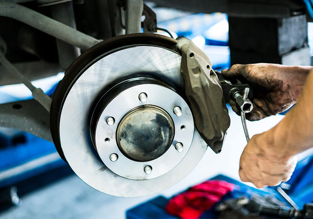Mechanic replacing brake pads on a Honda Civic
